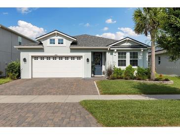 Charming single-story home with a two-car garage, paver driveway, and well-maintained lawn at 2401 Morninglight Dr, Lutz, FL 33558