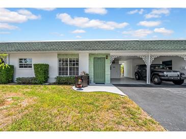 Charming home featuring a well-maintained lawn, covered parking, and a quaint entrance at 7850 40Th N Ave # 7850, St Petersburg, FL 33709