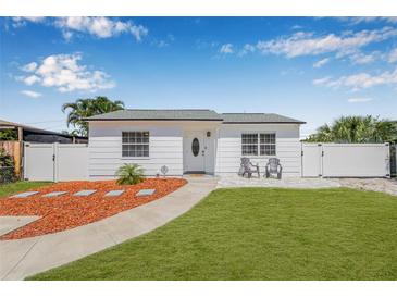 Charming single-story home with freshly manicured lawn, inviting entryway, and white picket fence at 812 60Th S St, Gulfport, FL 33707