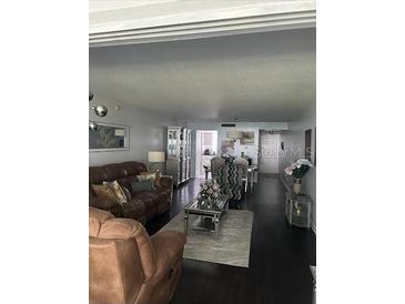Inviting living room with comfortable leather seating, dark hardwood floors, and bright natural light at 1220 57Th N St # 103C, St Petersburg, FL 33710
