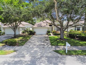 Charming one-story home with a two-car garage, driveway, mature trees and manicured landscaping at 2216 Evans Rd, Clearwater, FL 33763