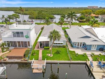 Waterfront home featuring a dock, canal access, lush landscaping, and a rooftop deck at 4012 Marine Pkwy, New Port Richey, FL 34652