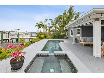 Inviting pool and spa area with beautiful landscaping and a view of the canal at 464 20Th Ave, Indian Rocks Beach, FL 33785