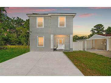 Charming two-story home with a welcoming front porch and a spacious concrete driveway at 7911 N Packwood Ave, Tampa, FL 33604