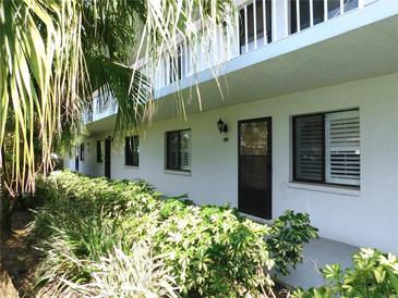Exterior view of a well-maintained two-story condo building surrounded by lush greenery and shrubbery at 111 Lakeview Pl, Oldsmar, FL 34677