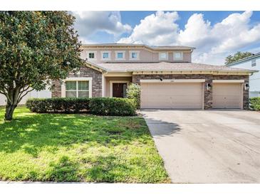 Charming two-story home with a three car garage, stone accents and well-manicured lawn at 1524 Rhodeswell Ln, Dover, FL 33527