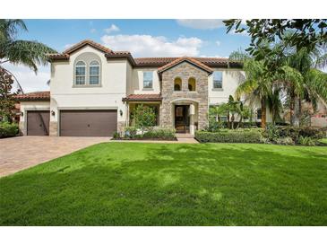 Charming two-story home with a stone entrance, lush landscaping, and a well-manicured lawn at 19711 Wellington Manor Blvd, Lutz, FL 33549