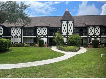 Attractive two-story condo with Tudor architecture, a manicured lawn, and a curved sidewalk at 240 N Bayshore Blvd # 102, Clearwater, FL 33759