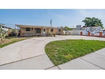 Home's front yard with a unique concrete driveway leading to the entrance and a patch of green grass at 4527 W Minnehaha St, Tampa, FL 33614