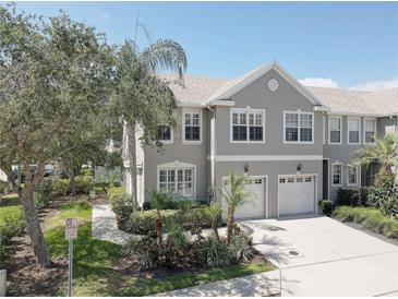 Charming townhome featuring a two-car garage, well-manicured landscaping, and a welcoming facade at 580 Shoreham Ne Ct, St Petersburg, FL 33716