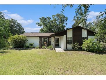 Charming one-story home with a well-maintained lawn and mature trees in a serene setting at 5960 Boyette Rd, Wesley Chapel, FL 33545