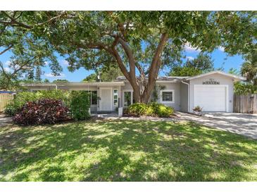 Charming single-story home featuring a manicured lawn and mature trees providing ample shade at 6618 12Th N St, St Petersburg, FL 33702