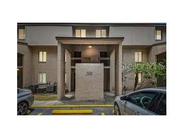 Beige two-story condo complex with covered entrance and limited parking; updated exterior and landscaping at 7523 Pitch Pine Cir # 184, Tampa, FL 33617