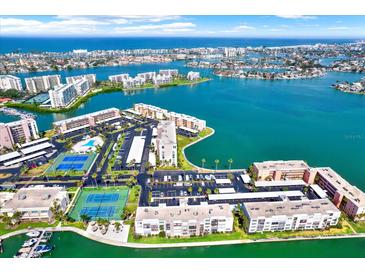 Panoramic aerial view of the waterfront complex featuring tennis courts, pools, and boating access at 7625 Sun Island S Dr # 304, South Pasadena, FL 33707