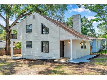 Charming home exterior showcasing a gable roof, white siding, and modern black-framed windows at 8521 N 29Th St, Tampa, FL 33604