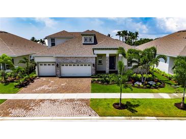 Beautiful single Gathering home with an attached three-car garage and meticulously manicured landscaping at 1028 Signet Dr, Apollo Beach, FL 33572