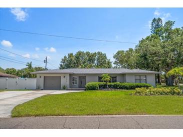 Charming single-story home with a well-manicured lawn and attached garage at 13514 Oval W Dr, Largo, FL 33774