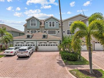 Inviting townhome with a 2 car garage, beautiful tile roof, and lush landscaping, ready for new homeowners at 1622 Lago Vista Blvd, Palm Harbor, FL 34685