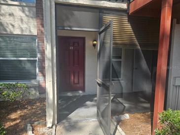 Inviting townhouse front door with screen door and lovely garden view at 3455 Countryside Blvd # 33, Clearwater, FL 33761