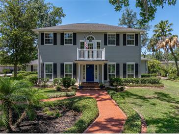 Charming two-story home with a brick walkway, blue door, and a balcony overlooking the landscaped front yard at 4611 Ackerly Way, Brandon, FL 33511