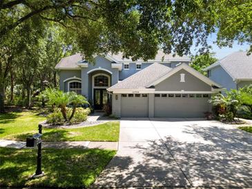 Beautiful two-story home with a three-car garage, mature landscaping, and a well-manicured lawn at 11723 Gothic Ln, Tampa, FL 33626
