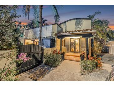 Inviting home exterior featuring a covered front entrance, lush landscaping, and unique architectural details at 122 Miramar Ne Blvd, St Petersburg, FL 33704