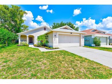 Charming single-story home featuring a well-manicured lawn and attached two-car garage at 22943 Sills Loop, Land O Lakes, FL 34639