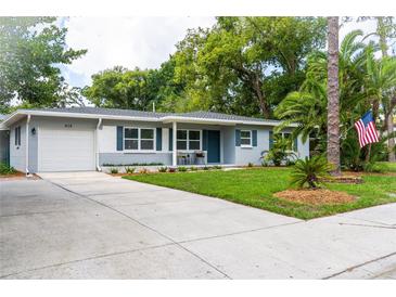 Charming single-story home with a well-maintained lawn, beautiful landscaping, and inviting curb appeal at 415 Mission Hills Ave, Temple Terrace, FL 33617