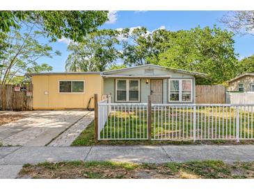Charming single-story home with a fenced yard and driveway, showcasing its inviting curb appeal at 4735 W Leila Ave, Tampa, FL 33616