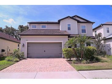 Charming two-story home featuring a paved driveway, two-car garage, and well-manicured landscaping at 10431 Alcon Blue Dr, Riverview, FL 33578