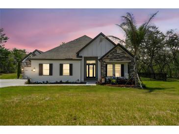 Charming single-story home featuring stone accents, a well-manicured lawn, and a welcoming entrance at 13334 Oldenburg Dr, Hudson, FL 34667