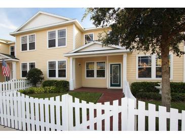 Charming two-story home with yellow siding, white picket fence, and well-maintained landscaping at 16137 Churchview Dr, Lithia, FL 33547