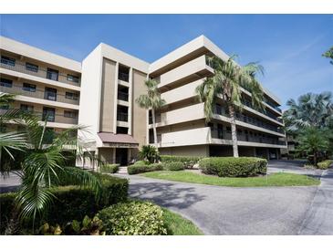 Modern condominium building featuring a well-maintained garden and mature palm trees at 1846 Golfview Dr # 1846, Tarpon Springs, FL 34689