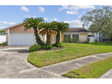 Charming single-story home with palm trees, lush lawn, and a two-car garage at 1944 Hastings Ln, Clearwater, FL 33763