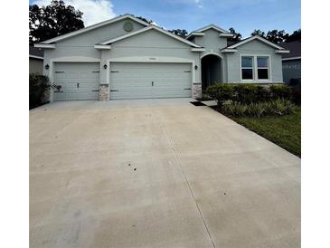 Charming single Gathering home with a three-car garage and well-maintained landscaping at 3504 Crooked River Dr, Plant City, FL 33565