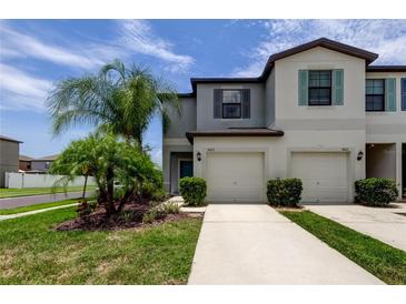 Charming townhome exterior with lush landscaping and a well-maintained front lawn at 4023 Wild Senna Blvd, Tampa, FL 33619