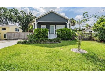 Charming home with a well-manicured front yard and lush landscaping on a bright, sunny day at 4205 N Suwanee Ave, Tampa, FL 33603