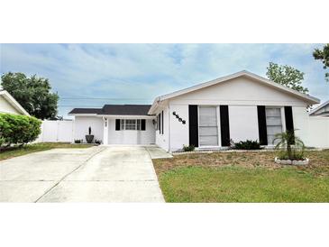 Charming single-story home with a white exterior, black shutters, and a well-maintained front yard at 6508 Lenore Dr, Tampa, FL 33634