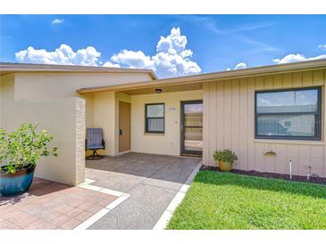 Inviting front entrance with a cozy seating area, decorative plants, and well-maintained landscaping at 6550 Teak Ct, Zephyrhills, FL 33542