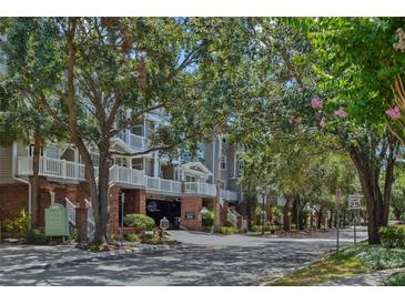 Beautiful condominium complex with mature trees, brick accents, and covered parking at 800 S Dakota Ave # 204, Tampa, FL 33606