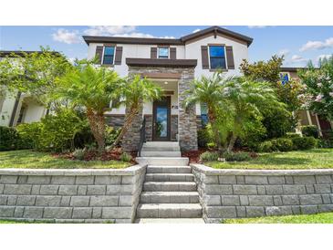 Inviting home featuring stone accents, beautiful landscaping with palm trees and an elevated stone staircase at 13311 Dorado Shores Ave, Riverview, FL 33579
