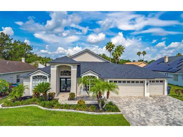 Beautiful single Gathering home featuring lush landscaping, paver driveway, and a three car garage at 18504 Country Crest Pl, Tampa, FL 33647