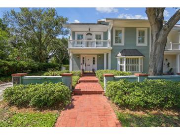 Charming two-story home with a red brick walkway, balcony, and manicured landscaping at 3105 W San Isidro St, Tampa, FL 33629