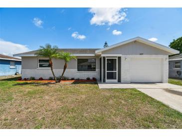 Charming single-story home featuring a well-maintained front yard with tropical landscaping and an attached garage at 6604 2Nd Ne Ave, Bradenton, FL 34208