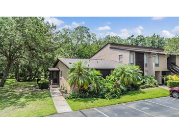 Charming condo with tropical landscaping and a private entrance, offering a welcoming curb appeal at 1400 Tarpon Woods Blvd # E4, Palm Harbor, FL 34685