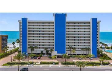 Bright and airy exterior shot of the condo building overlooking tropical landscaping and the ocean at 14950 Gulf Blvd # 905, Madeira Beach, FL 33708