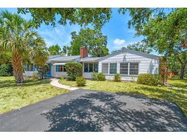 Charming single-story home with a well-manicured lawn, a brick chimney, and a sunny front yard at 601 75Th St N, St Petersburg, FL 33710