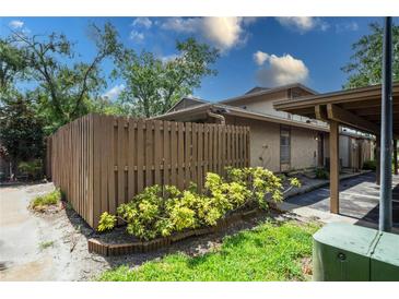 Home exterior featuring wood fence, green landscaping, and reserved parking at 802 Antler Ct, Brandon, FL 33511