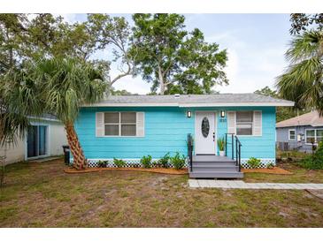 Charming turquoise bungalow featuring a well-manicured lawn, fresh landscaping, and a welcoming front entrance at 1820 Douglas Ave, Clearwater, FL 33755