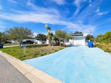 Charming single-story home featuring a vibrant blue driveway and well-manicured lawn at 2066 High Ridge Dr, Clearwater, FL 33763
